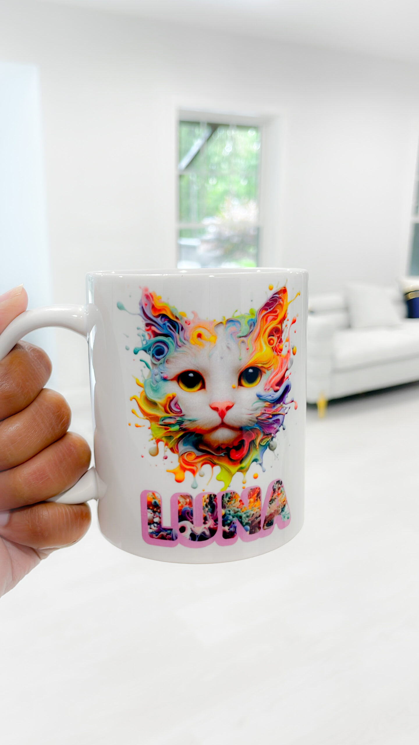 White ceramic mug with a colorful splash-art cat illustration and the name “LUNA” in bold multicolored text.